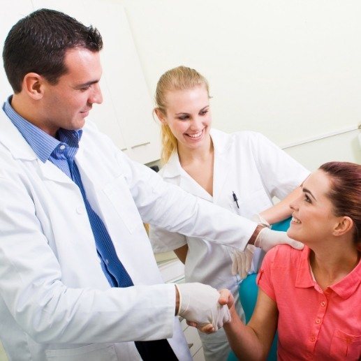 Dentist and dentistry team member talking to dental patient