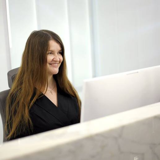 Smiling woman behind dental office front desk