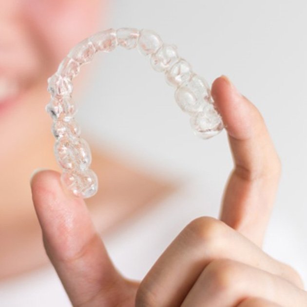 a person holding their Invisalign clear tray