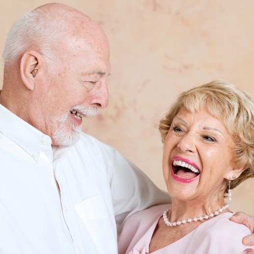 Older couple smiling with dental implants