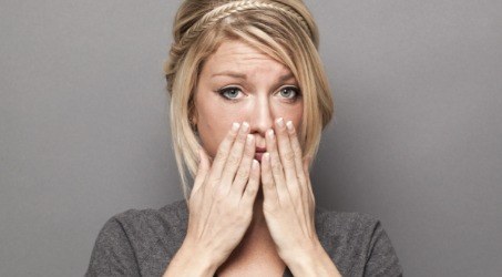 Woman with multiple missing teeth covering her mouth