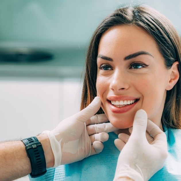 Dentist examining dental patient's smile during preventive dentistry visit