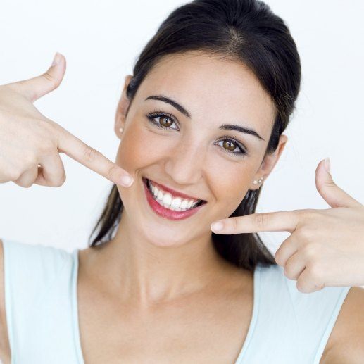 Woman pointing to smile after makeover