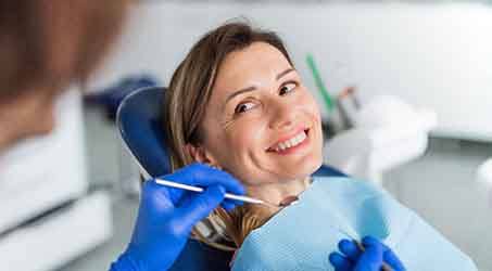 woman having her teeth cleaned at the dentist’s