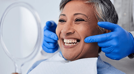 a patient smiling after receiving her dental implants