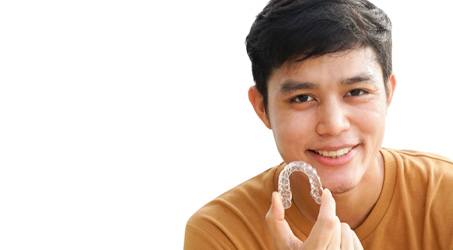 a person holding Invisalign aligners