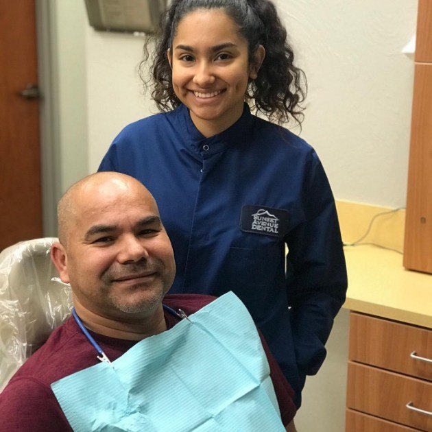 Dental team member and dentistry patient smiling after dental services in Springdale Arkansas