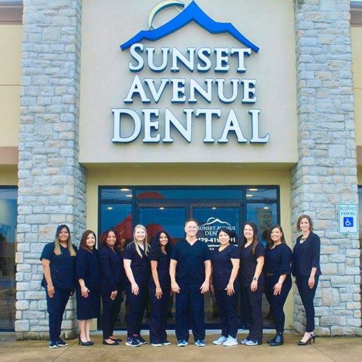 Dental team outside the Sunset Avenue Dental logo