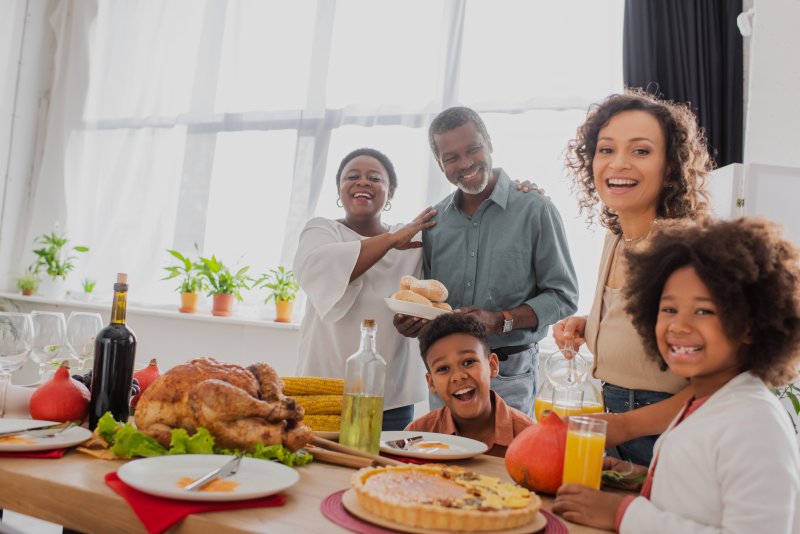 a family smiling and preparing for Thanksgiving dinner